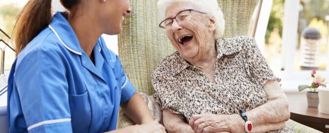 Senior Woman Sitting and Laughing with Nurse