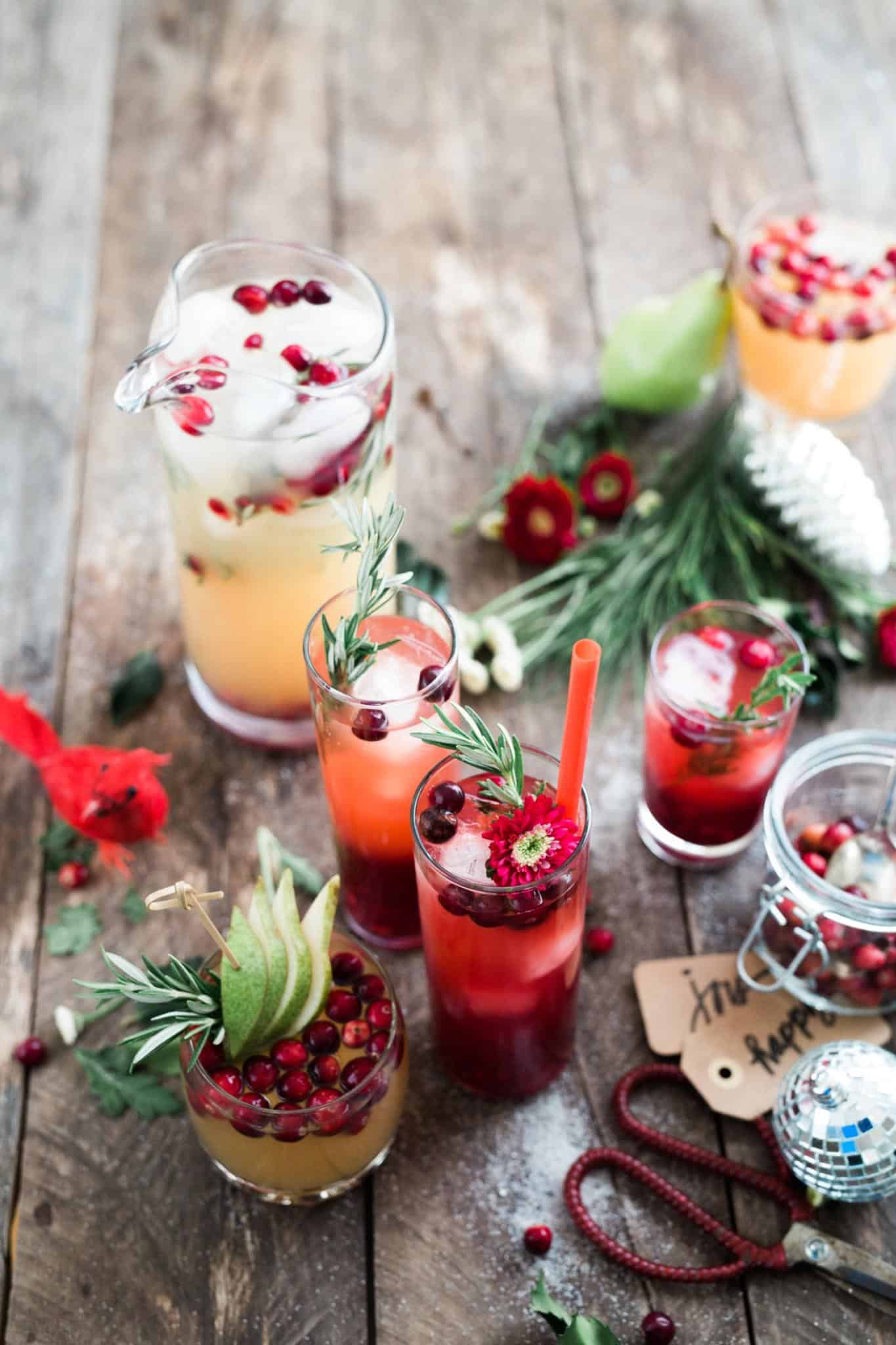 Arrangement of Holiday drinks and garnishments on a wooden table.
